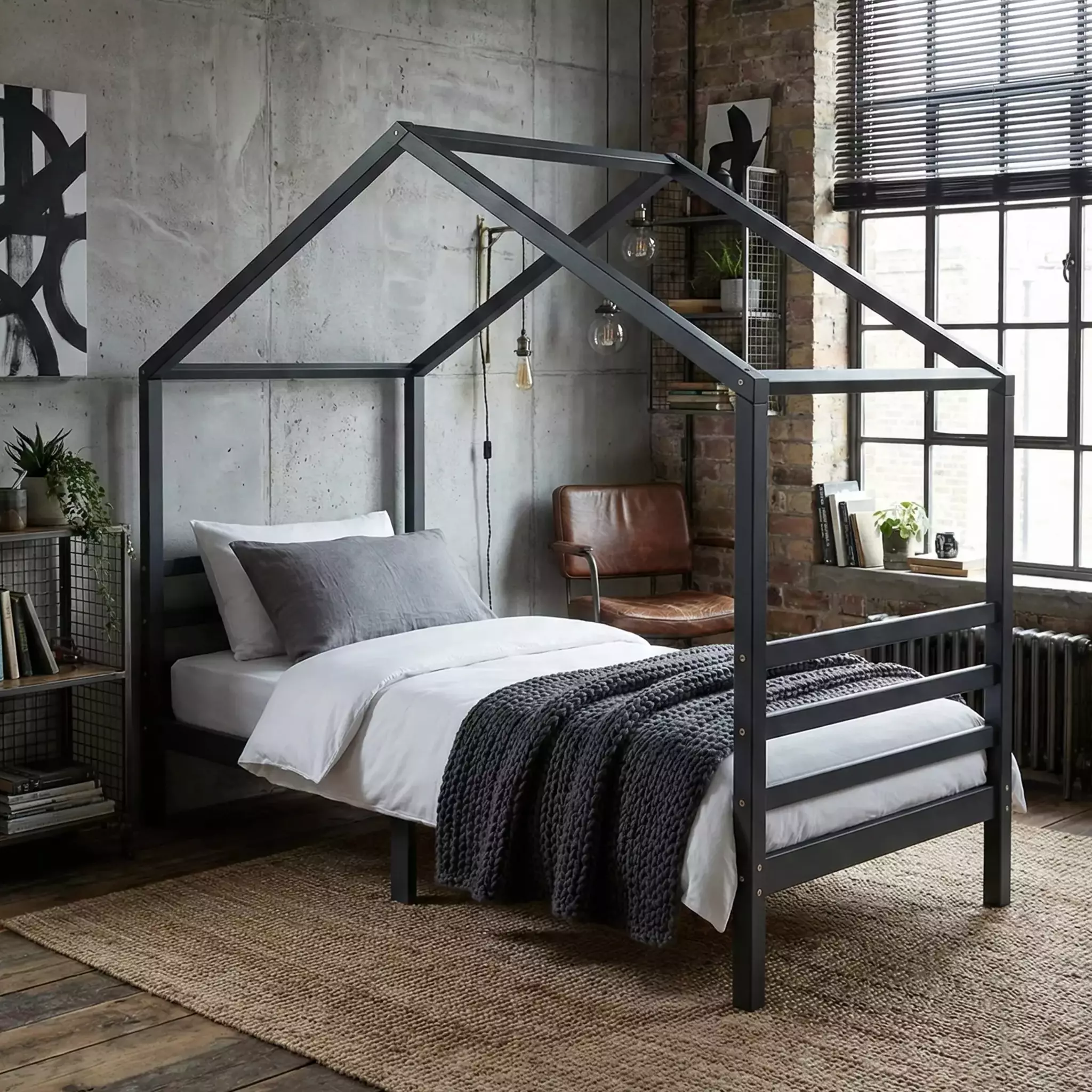 Hausbett Jugendbett 90x200 in Anthrazit im Jugendzimmer mit Betonwand, Ziegelmauer und Ledersessel